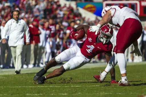 Alabama running back Brian Robinson Jr. (4) makes a hard cut on a run as New Mexico State linebacker Nick Giacolone (24) pursues during the first half of an NCAA college football game, Saturday, Nov. 13, 2021, in Tuscaloosa, Ala. (AP Photo/Vasha Hunt)