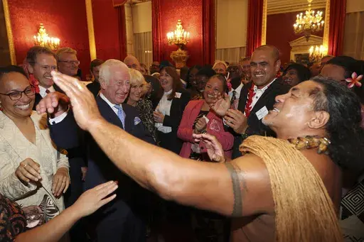 Britain's King Charles III, second from left, and Queen Camilla, third from left, smile as former Samoan rugby player Freddie Tuilagi dances during a reception to celebrate the Commonwealth Diaspora of the United Kingdom, ahead of the Commonwealth Heads of Government Meeting in Samoa, at St. James's Palace, London, on Oct. 2, 2024. (Adrian Dennis, Pool Photo via AP, File)
