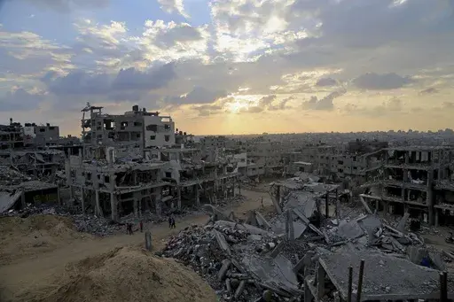 Palestinians walk between the rubble of a destroyed building in Shijaiyah neighborhood of Gaza City in the northern Gaza Strip, Oct. 12, 2014. An urban battle during the 2014 Gaza war offers a glimpse of what an Israeli ground offensive would look like, in 2023. (AP Photo/Adel Hana, File)