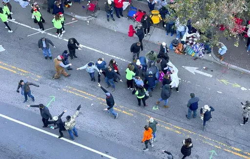 Personnel rush to where a person was injured during the Raleigh Christmas Parade on Hillsborough Street in Raleigh, N.C., Saturday, Nov. 19, 2022. Witnesses say people attending the Raleigh Christmas Parade heard the truck's driver screaming that he had lost control of the vehicle and couldn’t stop it before the crash.( (Ethan Hyman/The News & Observer via AP)