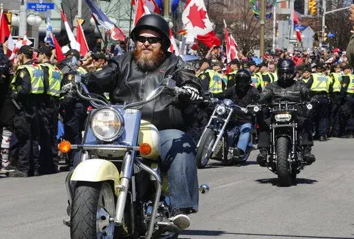 Demonstrators on motorcycles ride near the National War Memorial, part of a convoy-style protest participants are calling "Rolling Thunder" in Ottawa, Ontario, on Saturday, April 30, 2022. (Patrick Doyle/The Canadian Press via AP)