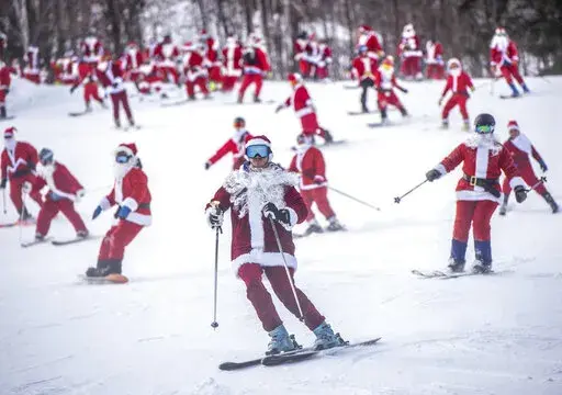 Skiers and snowboarders hit the slopes Sunday, Dec. 5, 2021 at Sunday River Ski Resort in Newry, Maine. The Santas gathered for the 21st annual Santa Sunday which raised over $4600 for the River Fund. (Andree Kehn/Sun Journal via AP)