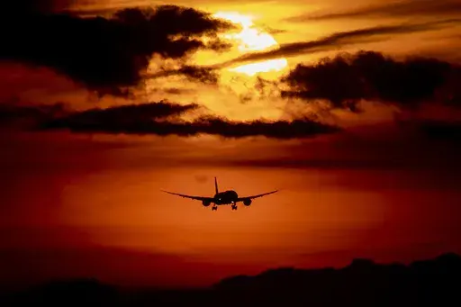 An aircraft approaches the airport in Frankfurt, Germany, as the sun rises on Thursday, Aug. 27, 2020. Mystery travel involves setting off on a trip where you only know the destination once you board the plane. These trips are popular among friend and family groups, and travel booking companies have begun offering mystery travel packages. (AP Photo/Michael Probst, File)