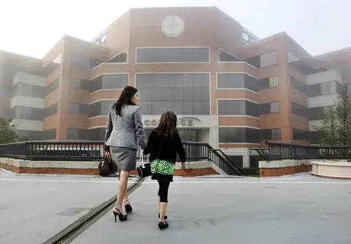 Alicia Agugliaro arrives at work with her 7-year-old daughter Eliana Agugliaro, on Thursday, April 22, 2010, in Princeton, N.J. The Take Our Daughters And Sons To Work Foundation is the nonprofit that promotes the day, which celebrates its 30th anniversary on Thursday. The foundation has fallen on hard times recently even as the idea it promotes endures. (AP Photo/Mel Evans, File)