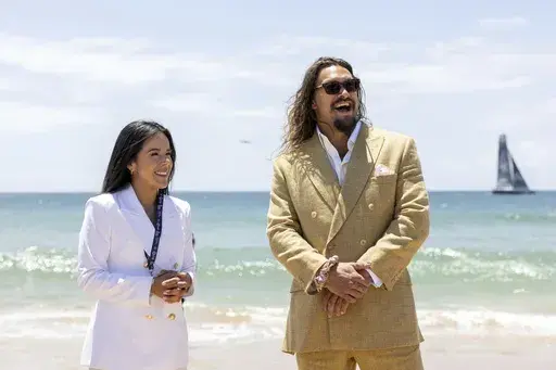 In this image provided by the the United Nations Youth and Innovation Forum, Daniela Fernandez, left, founder and CEO of Sustainable Ocean Alliance, and actor and ocean activist Jason Momoa smile during a ceremony at the UN Ocean Conference where Momoa was made a United Nations advocate for Life Below Water in June, 2022, in Cascais, Portugal. Fernandez has no trouble attracting volunteers to her group Sustainable Ocean Alliance. Last month, she presided over the Our Ocean Youth Leadership Summi