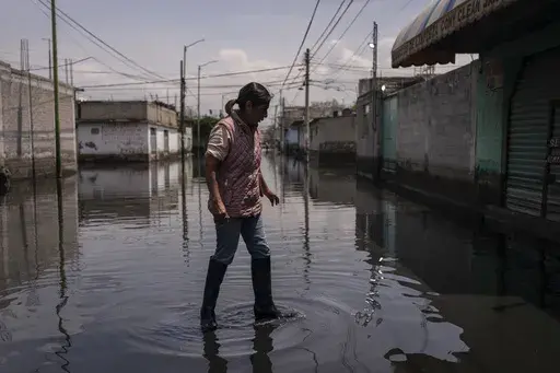 Juana Salazar Segundo walks through sewage-infused floodwaters in Valle de Chalco, State of Mexico, Thursday, Aug. 29, 2024. (AP Photo/Felix Marquez)