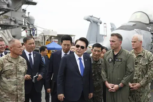 South Korean President Yoon Suk Yeol, center, boards the USS Theodore Roosevelt aircraft carrier at the South Korean naval base in Busan, South Korea, Tuesday, June 25, 2024. The newly-inaugurated Freedom Edge exercise is wrapping up in the East China Sea, having brought together Japanese, South Korean and American naval assets for multi-domain maneuvers for the first time. (South Korean Presidential Office/Yonhap via AP, File)
