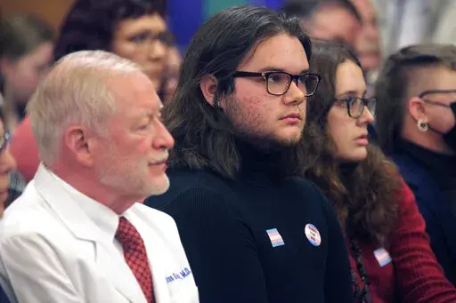 Adam Kellogg, center, a University of Kansas student and transgender man, follows a Kansas Senate health committee hearing on legislation aimed at preventing gender-affirming care for minors, Tuesday, Feb. 14, 2023, at the Statehouse in Topeka, Kan. The Republican-controlled Kansas Legislature is also considering a measure to define male and female in state law in such a way that it could prevent transgender men and women from changing their driver's licenses and birth certificates. (AP Photo/Jo