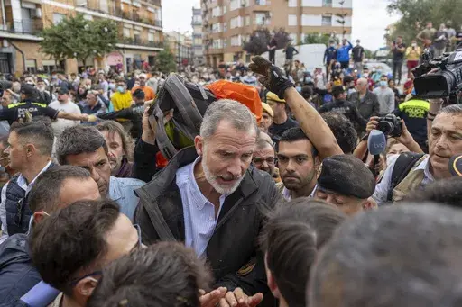 Spain's King Felipe VI speaks with people amidst angry Spanish flood survivors in Paiporta, near Valencia, Spain, Sunday Nov. 3, 2024. (AP Photo/David Melero)