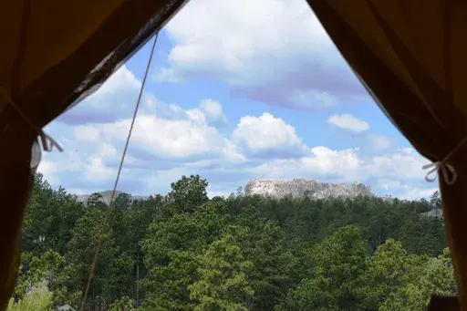 The view of Mount Rushmore located just a few miles away from Under Canvas Mount Rushmore tent cabins near Keystone, S.D. More than 10.5 million North American households took a glamping trip in 2022, up from 9.6 million in 2021. (Jim Holland/Rapid City Journal via AP, File)