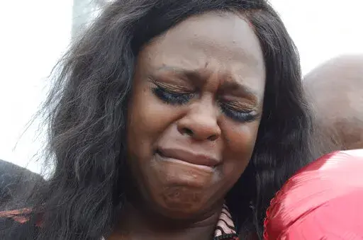 Kyoukius Washington cries before releasing a balloon in memory of her son Oterious 'Bull' Marks, who died in a drive-by shooting, Central Park in McComb, Miss., on Monday, Feb. 21, 2022. A drive-by shooting at a Mississippi park left a 6-year-old boy dead and four others wounded, authorities said. (Matt Williamson/The Enterprise-Journal via AP)