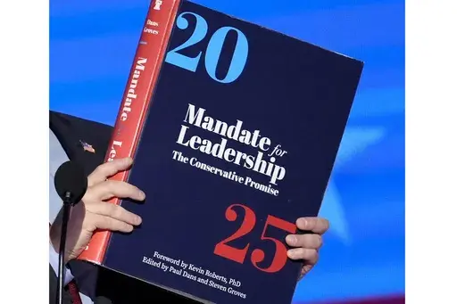A copy of Project 2025 is held during the Democratic National Convention, Aug. 21, 2024, in Chicago. For a year, Project 2025 has endured as a persistent force in the presidential election. It’s rare for a complex 900-page policy book to figure so dominantly in a political campaign. (AP Photo/J. Scott Applewhite)