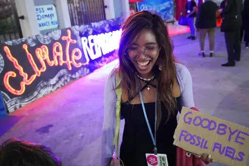 Climate activist Mitzi Jonelle Tan, of the Philippines, holds a sign that reads "goodbye fossil fuels" during a demonstration at the COP27 U.N. Climate Summit, Friday, Nov. 18, 2022, in Sharm el-Sheikh, Egypt. (AP Photo/Peter Dejong)