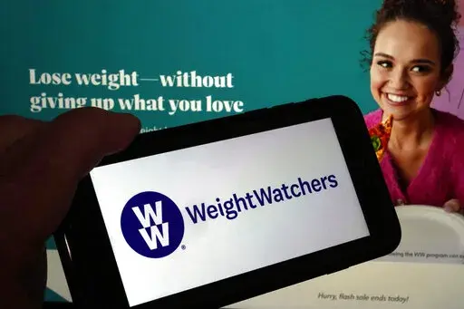 This image shows the logo of WeightWatchers on a mobile phone, and the company's website, in New York, Tuesday, March 7, 2023. WeightWatchers shares soared Tuesday after the company said it was getting into the prescription drug weight loss business with the acquisition of Sequence. (AP Photo/Richard Drew)