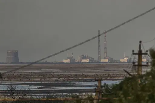 The Zaporizhzhia nuclear power plant, Europe's largest, is seen in the background of the shallow Kakhovka Reservoir after the dam collapse, in Energodar, Russian-occupied Ukraine, Tuesday, June 27, 2023. Ukraine and Russia accused each other Wednesday, July 5, 2023, of planning to attack the power plant, which is occupied by Russian troops, but neither side provided evidence to support their claims. (AP Photo/Libkos, File)