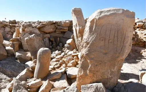 This photo provided by Jordan Tourism Ministry shows two carved standing stones at a remote Neolithic site in Jordan’s eastern desert.  A team of Jordanian and French archaeologists said Tuesday, Feb. 22, 2022,  that it had found a roughly 9,000-year-old shrine.  The ritual complex was found in a Neolithic campsite near large structures known as “desert kites," or mass traps that are believed to have been used to corral wild gazelles for slaughter. (Tourism Ministry via AP)