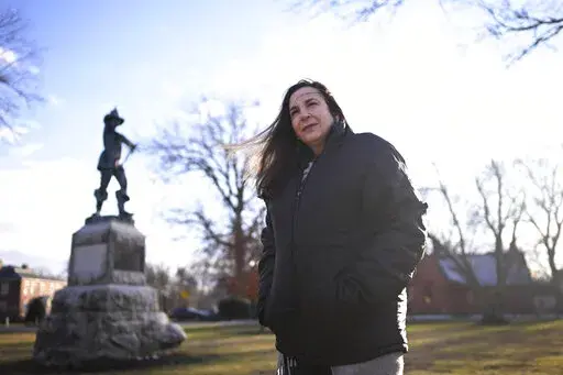 In this Tuesday, Jan. 24, 2023 photo, Beth Caruso, author and co-founder of the CT Witch Trial Exoneration Project, which was created to clear the names of the accused, stands on the Palisado Green in Windsor, Conn., where in 1651, an accident during a local militiamen training exercise led to the accusation of witchcraft and hanging of Lydia Gilbert. Now, more than 375 years later, amateur historians, researchers and descendants of the accused witches and their accusers, from across the U.S., a