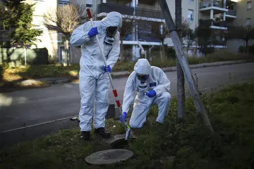 Firefighters from the Marins-Pompiers of Marseille extract samples of sewage water at a retirement home in Marseille, southern France, Thursday Jan. 14, 2021, to trace concentrations of COVID-19 and the highly contagious variant that has been discovered in Britain. As coronavirus infections rise in some parts of the world, experts are watching for a potential new COVID-19 surge in the U.S. — and wondering how long it will take to detect. (AP Photo/Daniel Cole)