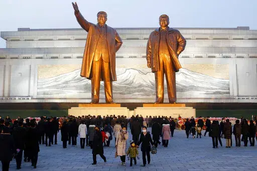 Citizens visit the bronze statues of their late leaders Kim Il Sung, left, and Kim Jong Il on Mansu Hill in Pyongyang, North Korea Thursday, Dec. 16, 2021, on the occasion of 10th anniversary of demise of Kim Jong Il. (AP Photo/Cha Song Ho)