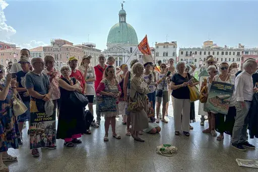 Activists gather outside Venice's Santa Lucia train station, July 13, 2024, to protest a day-tripper fee that they say has failed to dissuade visitors from arriving on peak days, as envisioned. (AP Photo/Colleen Barry, File)