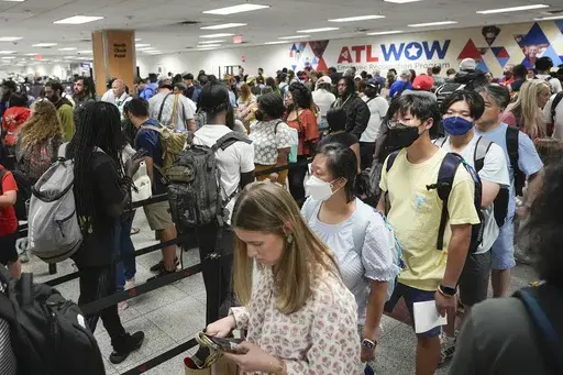 Travelers line up for security clearance at Hartsfield-Jackson Atlanta International Airport on Friday, June 28, 2024, in Atlanta. Travel activity is expected to heat up to record levels around the Independence Day holiday as consumers take advantage of cooler prices for airfares, gasoline and hotels. (AP Photo/Pablo Martinez Monsivais, File)