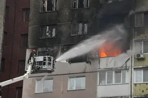 Firefighters work to extinguish a fire in an apartment building after Russian attack in Kyiv, Ukraine, Wednesday, Feb. 7, 2024. Authorities say Russia has fired cruise and ballistic missiles and Shahed-type drones at targets across Ukraine including the capital Kyiv. Officials said the Wednesday morning attack killed at least one civilian and injured 10 others. (AP Photo/Efrem Lukatsky)
