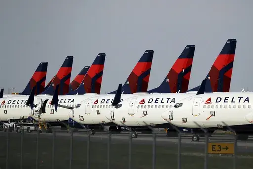 In this April 1, 2020, file photo, several dozen Delta Air Lines jets are parked at Kansas City International Airport in Kansas City, Mo. Delta is backtracking slightly on changes it previously announced in its frequent-flyer program, but it still plans to reshape SkyMiles to favor big spenders over customers who take the most flights. Delta outlined the revisions in an email from CEO Ed Bastian to SkyMiles members on Wednesday, Oct. 18, 2023. (AP Photo/Charlie Riedel, File)