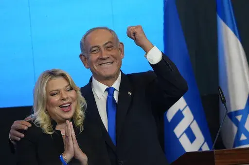 Former Israeli Prime Minister and the head of Likud party, Benjamin Netanyahu and his wife Sara gesture after first exit poll results for the Israeli Parliamentary election at his party's headquarters in Jerusalem, Wednesday, Nov. 2, 2022. Netanyahu and his allies on Thursday denounced protesters as "anarchists" after they massed outside a Tel Aviv salon where his wife was getting her hair done, a chaotic end to a day of demonstrations against the government's plan to overhaul the judiciary. (AP