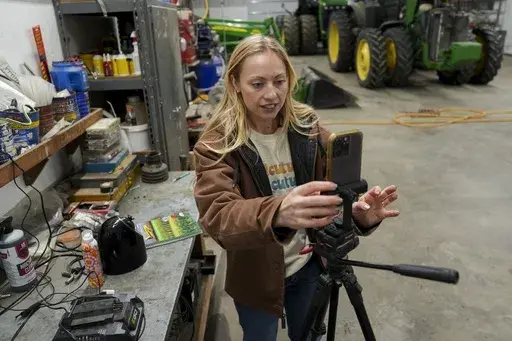 Zoe Kent prepares to create a social media video, Monday, Jan. 20, 2025, at her farm in Bucyrus, Ohio. (AP Photo/Joshua A. Bickel)