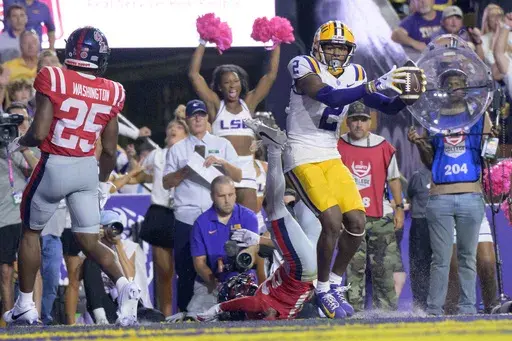 LSU wide receiver Kyren Lacy (2) grabs the winning touchdown in overtime against Mississippi safety Jadon Canady (28) in an NCAA college football game in Baton Rouge, La., Saturday, Oct. 12, 2024. (AP Photo/Matthew Hinton)