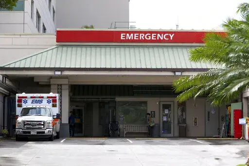 FILE — In this Aug. 24, 2021, file photo an ambulance sits outside the emergency room at The Queen's Medical Center in Honolulu.  As of Jan. 1, 2022, most surprise medical bills are now banned as a result of the No Surprises Act. Surprise medical bills commonly arise when you can’t choose your provider, such as in an emergency or when you’re assigned an anesthesiologist or radiologist.  (AP Photo/Caleb Jones, File)