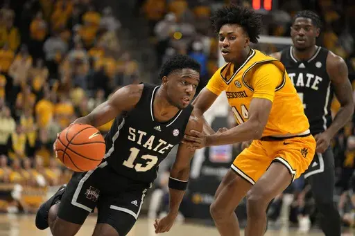 Mississippi State's Josh Hubbard (13) heads to the basket past Missouri's Anthony Robinson II (14) during the first half of an NCAA college basketball game Saturday, Feb. 10, 2024, in Columbia, Mo. (AP Photo/Jeff Roberson)