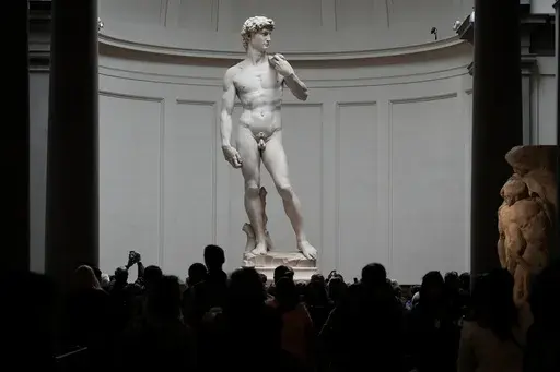 Visitors stand in front of Michelangelo's "David statue" in the Accademia Gallery in Florence, Italy, Tuesday, March 28, 2023. The Florence museum and the city's mayor are inviting parents and students from a Florida charter school to visit and see Michelangelo's sculpture of David. The invitation comes after the school principal was forced to resign following parental complaints that an image of the nude Renaissance masterpiece was shown to a sixth-grade art class. (AP Photo/Alessandra Tarantin
