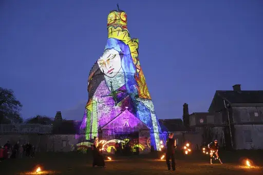 Dancers perform in front of an image of St. Brigid projected onto The Wonderful Barn in Leixlip, Kildare, Ireland, Tuesday, Jan. 31, 2023 during the Herstory Festival of Light. Devotees of St. Brigid in Ireland plan to celebrate on Sunday, Jan. 28, 2024, with the scheduled return of a relic associated with the so-called “matron saint of Ireland” — about a millennium after her remains were removed from her hometown of Kildare. It's part of a series of observances in Ireland and around the w