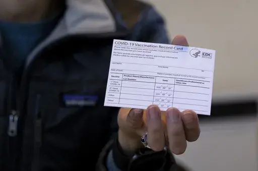 A nurse practitioner holds a COVID-19 vaccine card at a New York Health and Hospitals vaccine clinic in the Brooklyn borough of New York on Jan. 10, 2021. Now that COVID-19 vaccines are being distributed through the commercial markets instead of by the federal government in 2023, the Centers for Disease Control and Prevention won't be shipping out any more new cards. (AP Photo/Craig Ruttle, File)