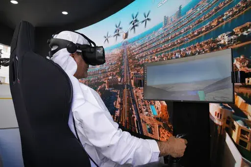 A man experiences a driving simulator of a flying taxi at the Dubai Roads and Transportation Authority's stand during the World Government SummitWLD in Dubai, United Arab Emirates, Monday, Feb 13, 2023. Dubai again is planning for the takeoff of flying taxis in this futuristic city-state on the Arabian Peninsula, offering its firmest details yet Monday for a pledged launch by 2026. (AP Photo/Kamran Jebreili)