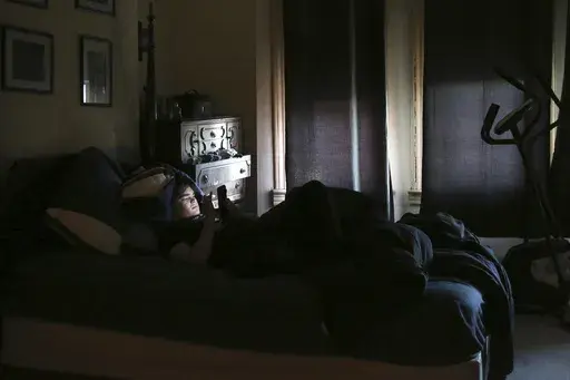 James Walter uses a phone at home in the Queens borough of New York, on April 7, 2021. Sleep scientists long ago established that insufficient sleep is linked with poor health outcomes, anxiety, obesity and several other negative effects. The research is equally conclusive that smartphones are particularly disruptive to the circadian clock that regulates sleep and other hormones. (AP Photo/Jessie Wardarski, File)