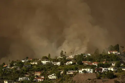 Smoke from the Palisades Fire rises over residences in Mandeville Canyon Saturday, Jan. 11, 2025, in Los Angeles. (AP Photo/Jae C. Hong, File)
