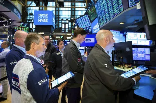 In this photo provided by the New York Stock Exchange, traders gather at a post on the floor, Friday, May 27, 2022, in New York. Stocks rose in morning trading on Wall Street Friday, keeping the market on track for its first weekly gain after seven weeks of losses. (Courtney Crow/New York Stock Exchange via AP)
