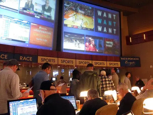 Gamblers line up to place bets on the NCAA men's college basketball tournament at the Borgata casino in Atlantic City N.J., March 21, 2019. When the NFL season kicks off, Kentucky residents will be able to legally bet on games for the first time. When they do, they also will be funding the state's first-ever program for people with gambling problems. (AP Photo/Wayne Parry, File)