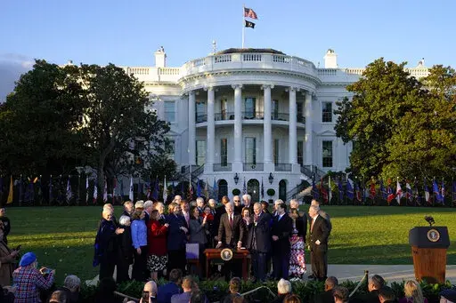 President Joe Biden sits to sign the "Infrastructure Investment and Jobs Act" during an event on the South Lawn of the White House, Monday, Nov. 15, 2021, in Washington. (AP Photo/Evan Vucci)