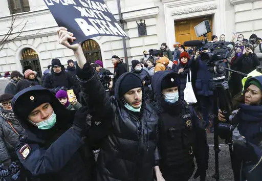 Police officers detain a demonstrator as people gather in front of the Supreme Court of the Russian Federation, in Moscow, Russia, Tuesday, Dec. 28, 2021. Russia’s Supreme Court has ruled that one of the country’s oldest and most prominent human rights organizations should be shut down. The move is the latest step in a months-long crackdown on dissent. The Prosecutor General’s Office last month petitioned the Supreme Court to revoke the legal status of Memorial — an international human r