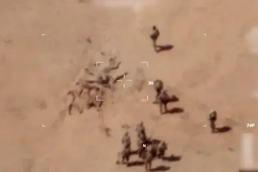 This image taken from a video shows soldiers burying bodies near an army base in northern Mali. The French military says it has videos of Russian mercenaries burying bodies near an army base in northern Mali which it says is part of a smear campaign against the French who handed control of the base to Malian forces earlier this week. Aerial surveillance taken by the French military early Thursday and provided to The Associated Press show what appear to be 10 Caucasian soldiers covering approxima