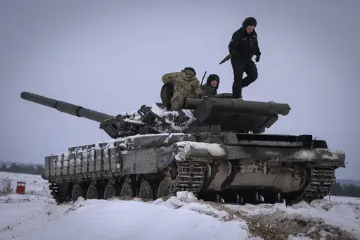 Ukrainian soldiers practice on a tank during military training, in Ukraine, Wednesday, Dec. 6, 2023. A gloomy mood hangs over Ukraine’s soldiers nearly two years after Russia invaded their country. Ukrainian soldiers remain fiercely determined to win, despite a disappointing counteroffensive this summer and signs of wavering financial support from allies. (AP Photo/Efrem Lukatsky, File)