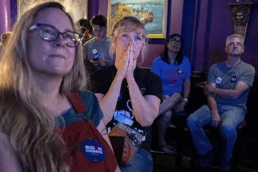 Lori Lahrmann left, and Tonya Morris, second from left, both from Cincinnati, watch the presidential debate between President Joe Biden and Republican presidential candidate former President Donald Trump at Tillie's Lounge on Thursday, June 27, 2024, in Cincinnati. Both plan to vote for President Joe Biden. (AP Photo/Carolyn Kaster)