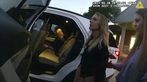 This image taken from body camera footage provided by Washington County Attorney's Office shows Jodi Hildebrandt, left, and Ruby Franke, center, being arrested on child abuse charges on Aug. 30, 2023, in Ivins, Utah. The twelve-year-old son of Franke, a Utah mother of six who gave parenting advice to millions via a once-popular a YouTube channel, had escaped through a window and approached several nearby homes until someone answered the door, according to documents released Friday. (Washington C