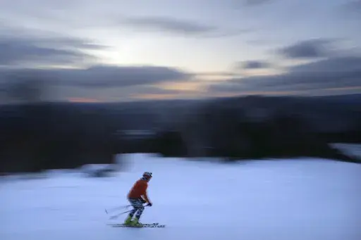 A skier descends Black Mountain of Maine, Feb. 11, 2023, in Rumford, Maine. A new study says U.S. ski areas lost about $5 billion from 2000 to 2019 as a result of human-caused climate change. (AP Photo/Robert F. Bukaty, File)