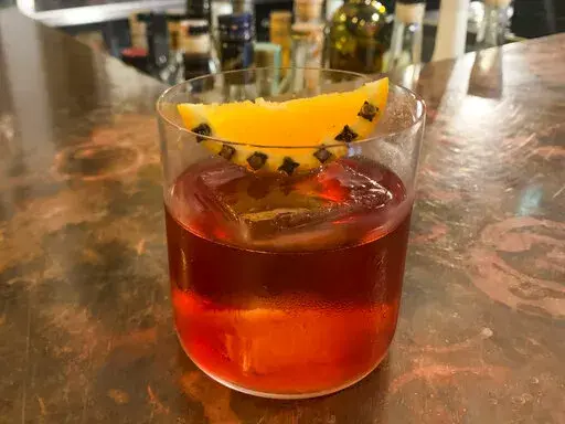This image shows a Wintertime Negroni cocktail. Looking to create a bit of winter luxury when tending bar at home this holiday season? London's top cocktail-makers have some tips. Salvatore Calabrese of the cocktail bar Velvet says to start with the right glassware. He says that if the glass looks elegant, the atmosphere is already festive. Then think about the ice, which he says is like heat for cooking. You want the drink to dilute just right, so you don't want cracked or crushed ice. Other ex