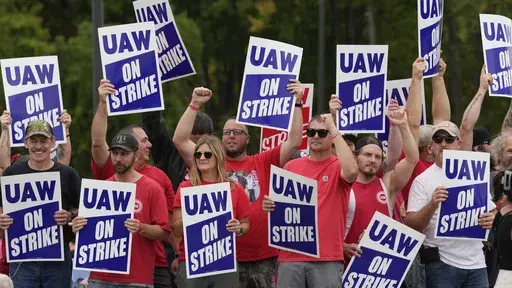 United Auto Workers members hold picket signs near a General Motors Assembly Plant in Delta Township, Mich., Sept. 29, 2023. As the auto workers strike approaches the one-month mark, more Americans sympathize with the striking workers than with the three big car companies that employ them. That's one of the findings in a new poll from The Associated Press-NORC Center for Public Affairs Research. (AP Photo/Paul Sancya)