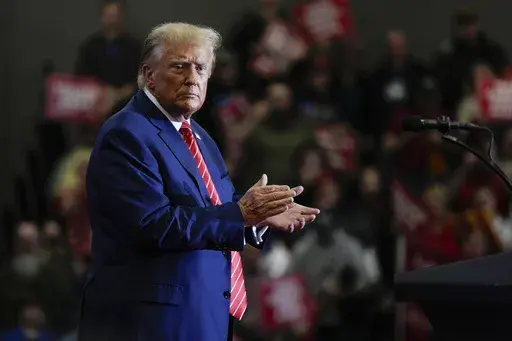 Republican presidential candidate former President Donald Trump stands on stage after speaking during a commit to caucus rally, Saturday, Jan. 6, 2024, in Clinton, Iowa. (AP Photo/Charlie Neibergall)